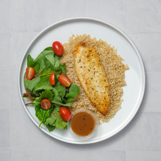 Tilapia sazonado con especias, quinoa orgánica y ensalada.